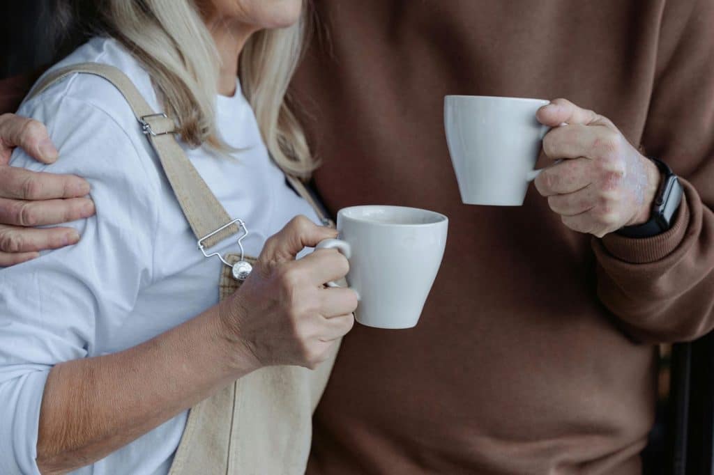 Two people holding a mug