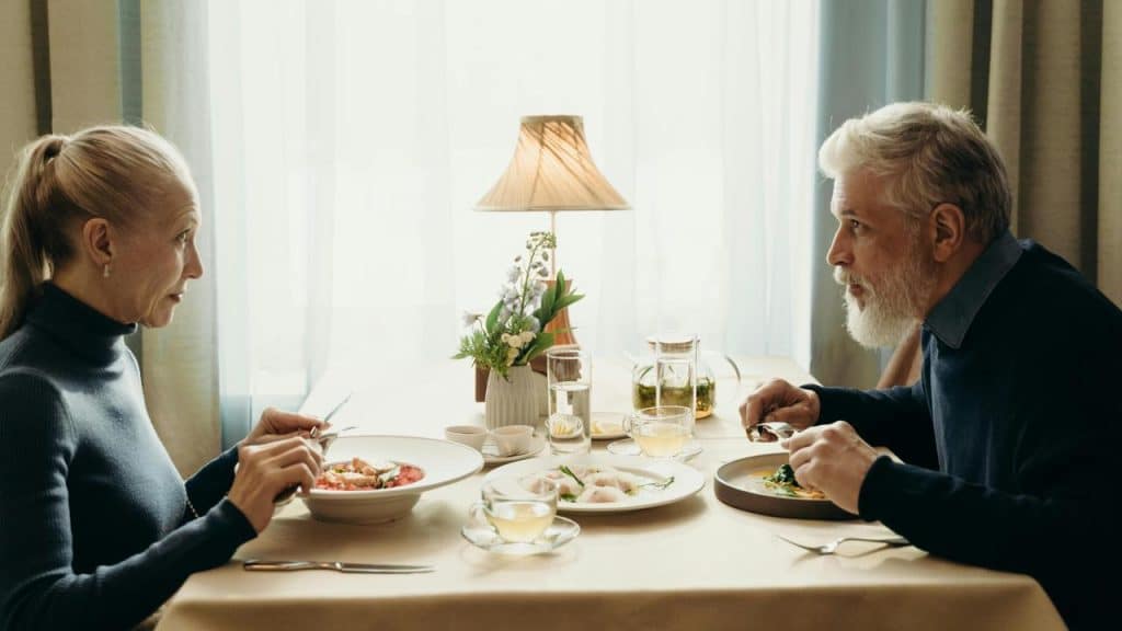A senior couple having a meal together at a restaurant table.