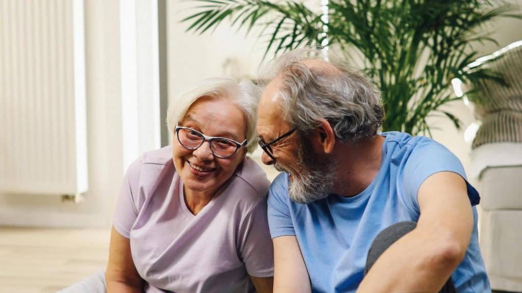 A senior couple sitting together and smiling.
