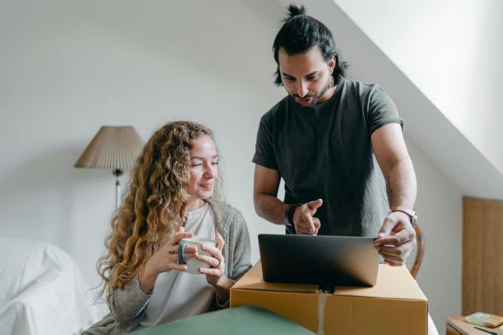 A man and woman looking at the laptop