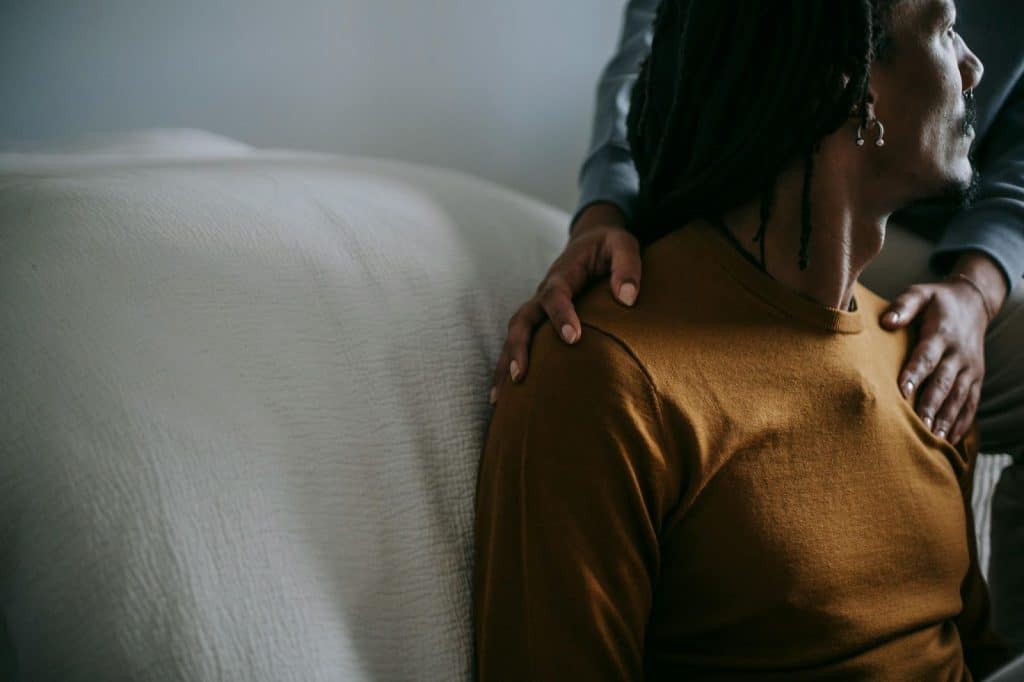 A woman holding the shoulder of a man