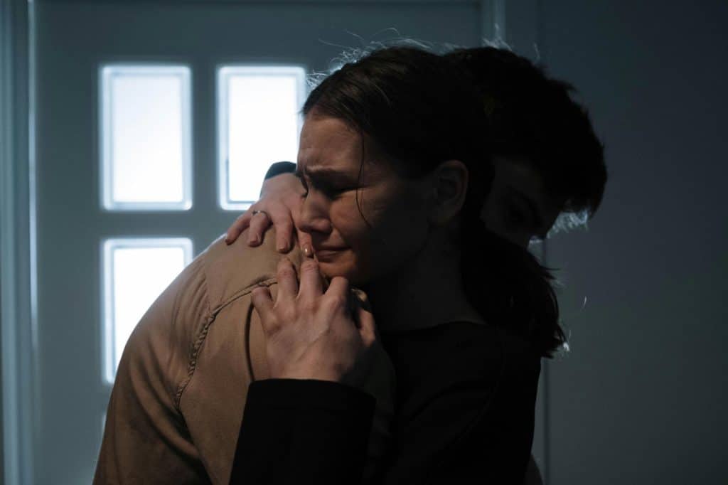 A man hugging a crying woman