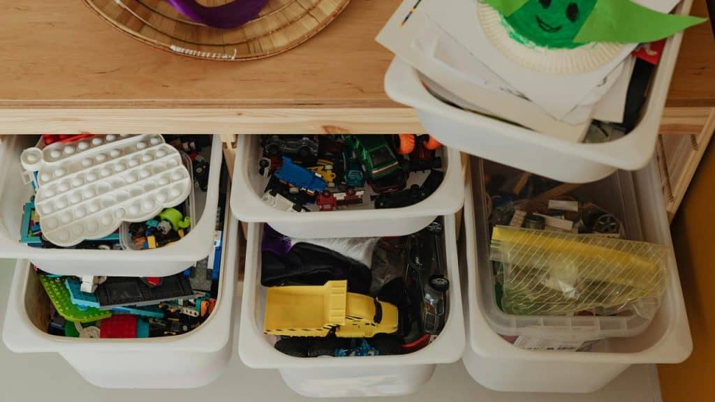 A set of plastic bins filled with children’s toys and art supplies.