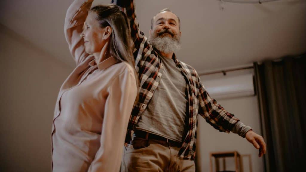 A couple dancing together at home.