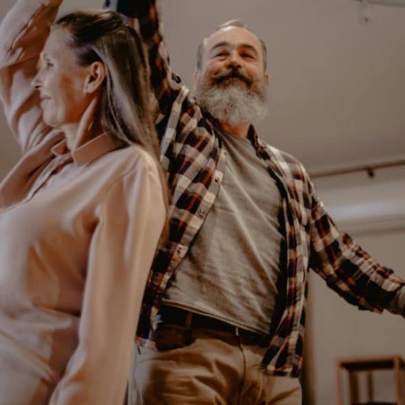 A couple dancing together at home.