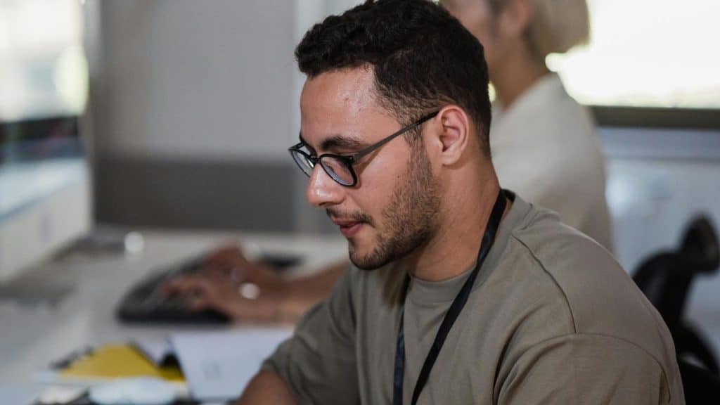 A man wearing glasses working at a desk.
