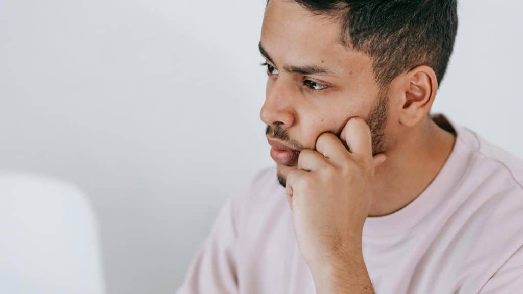 A man resting his chin on his hand while looking ahead.