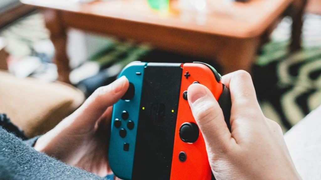 A person holding a Nintendo switch joycon controller.