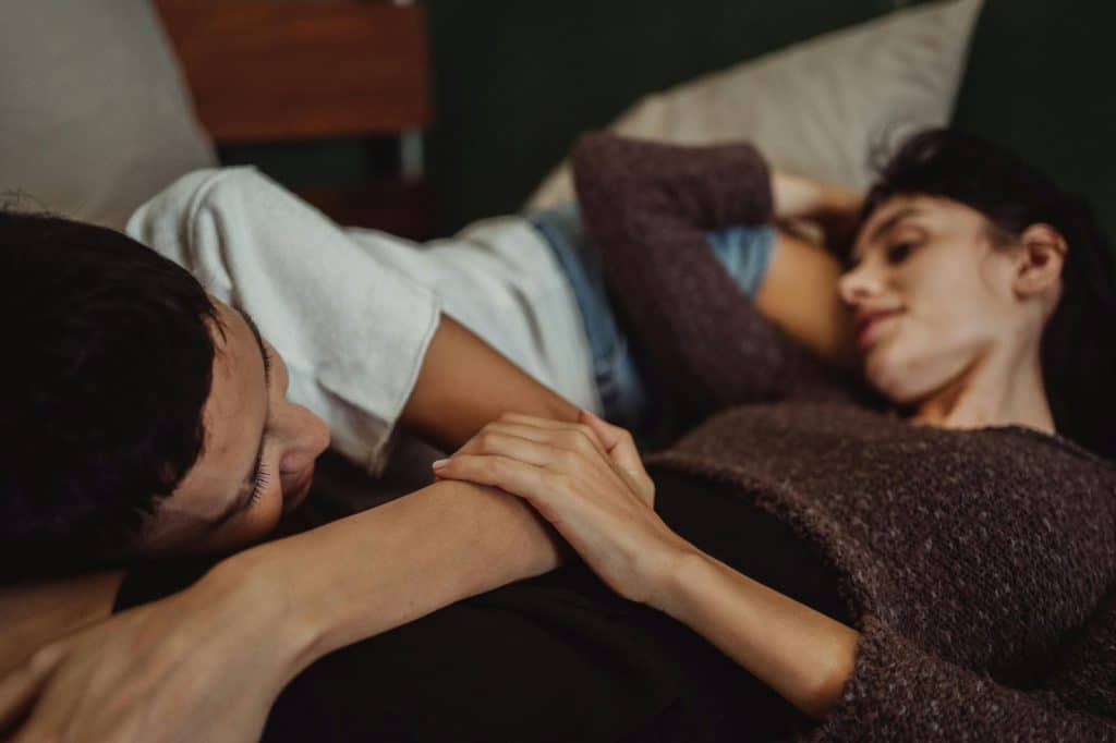 A man and woman talking while lying on bed