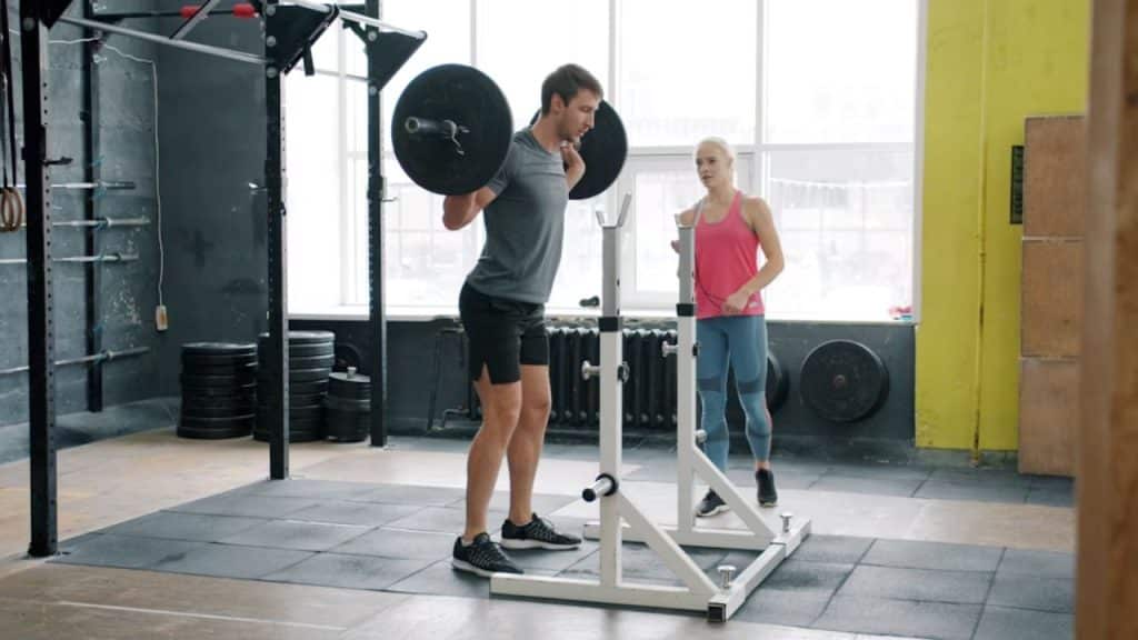 Man lifting weights while partner cheers from the side