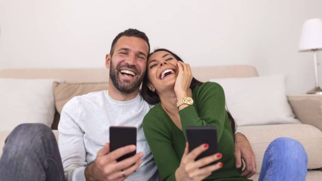 Couple laughing together while sitting on the floor