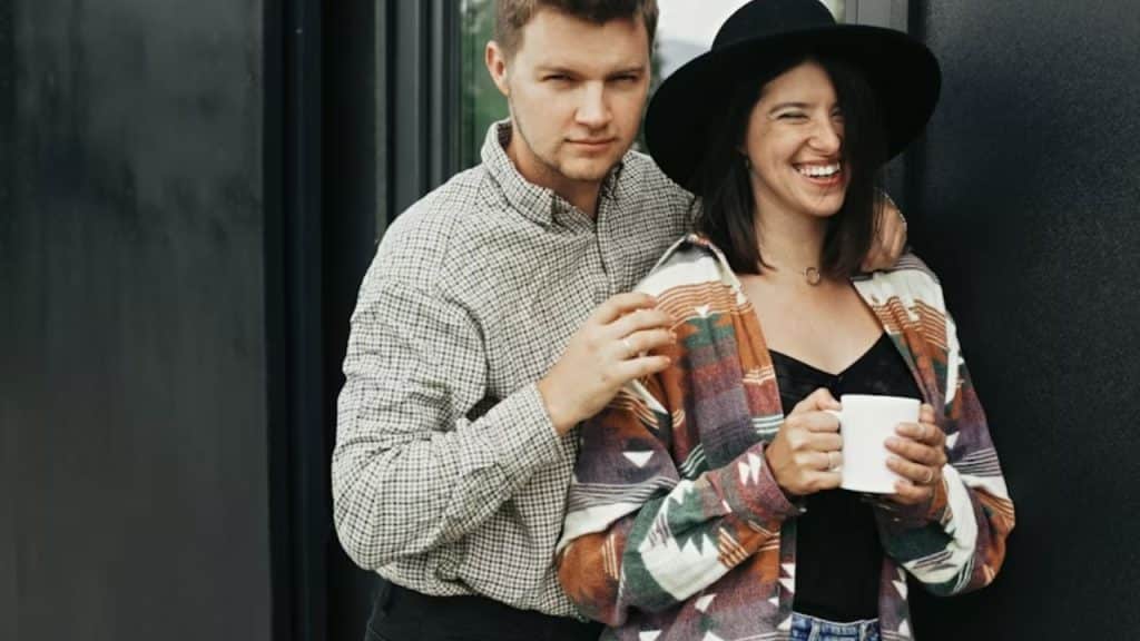 Man handing his partner a cup of coffee with a smile