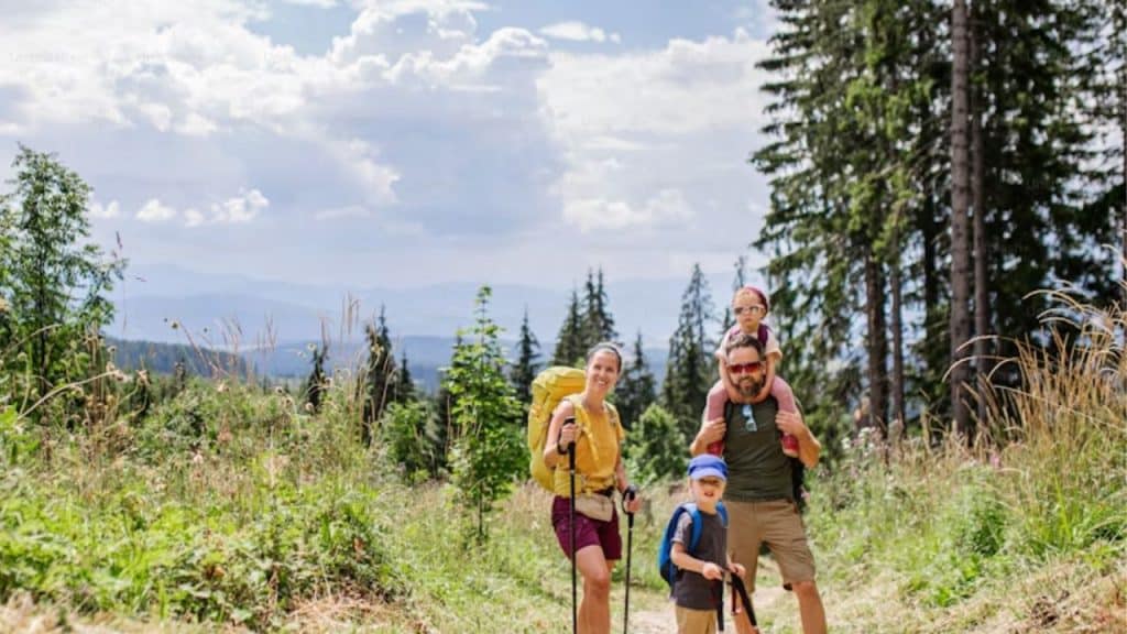 Husband guiding family through a hike outdoors
