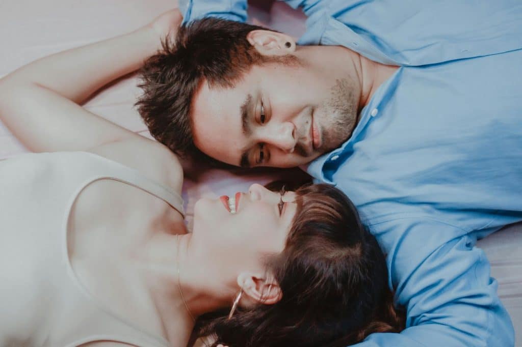 A man and woman laying on bed