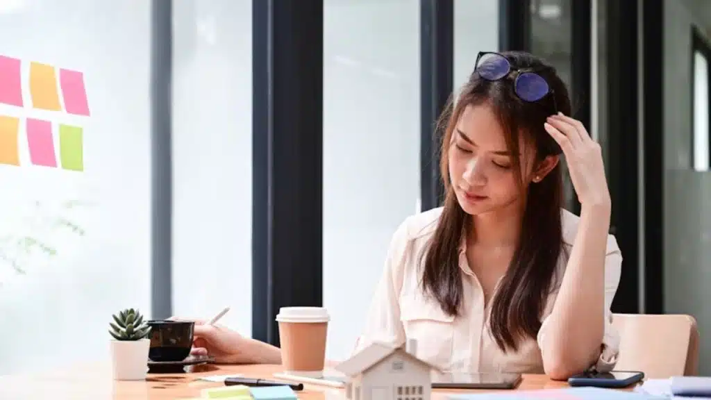A woman taking a deep breath in a busy office