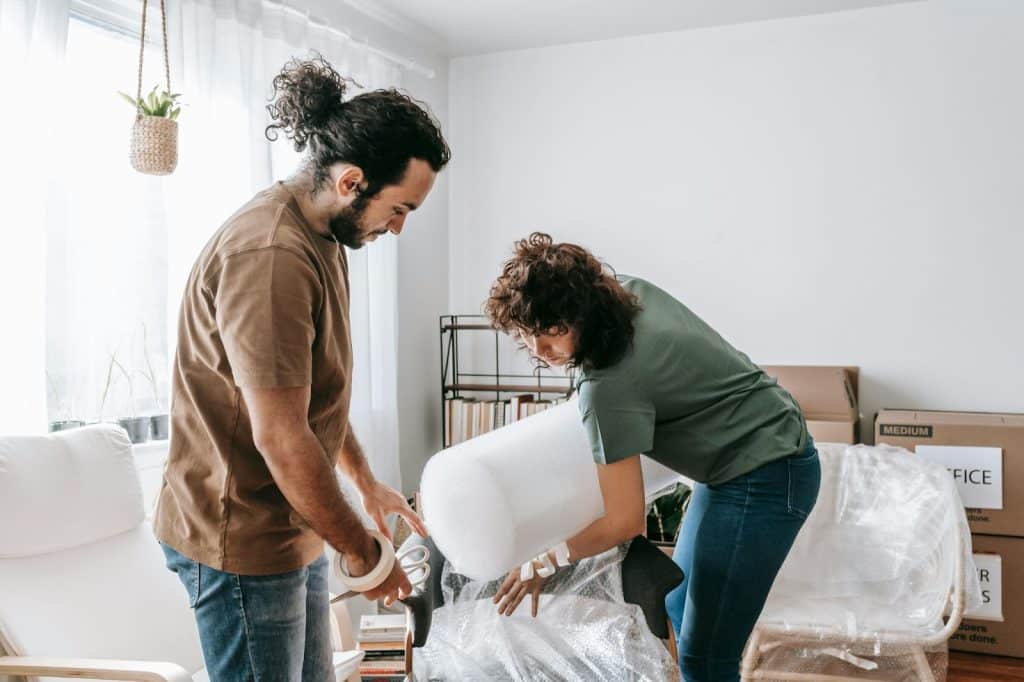 A man and woman helping each other for things in their house
