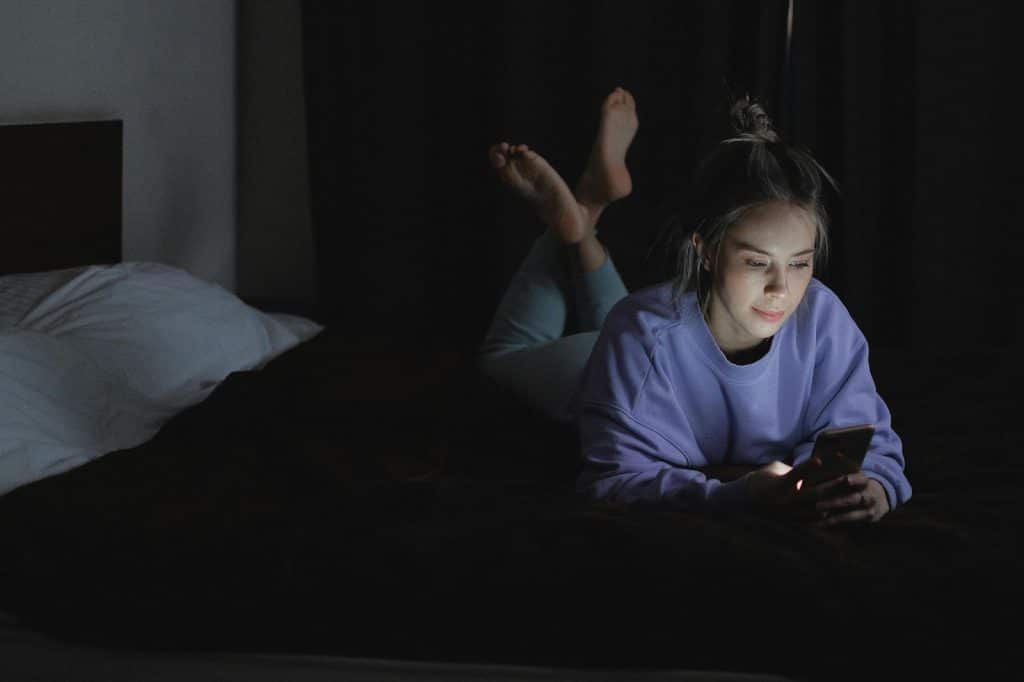 A woman using a phone in a dark room