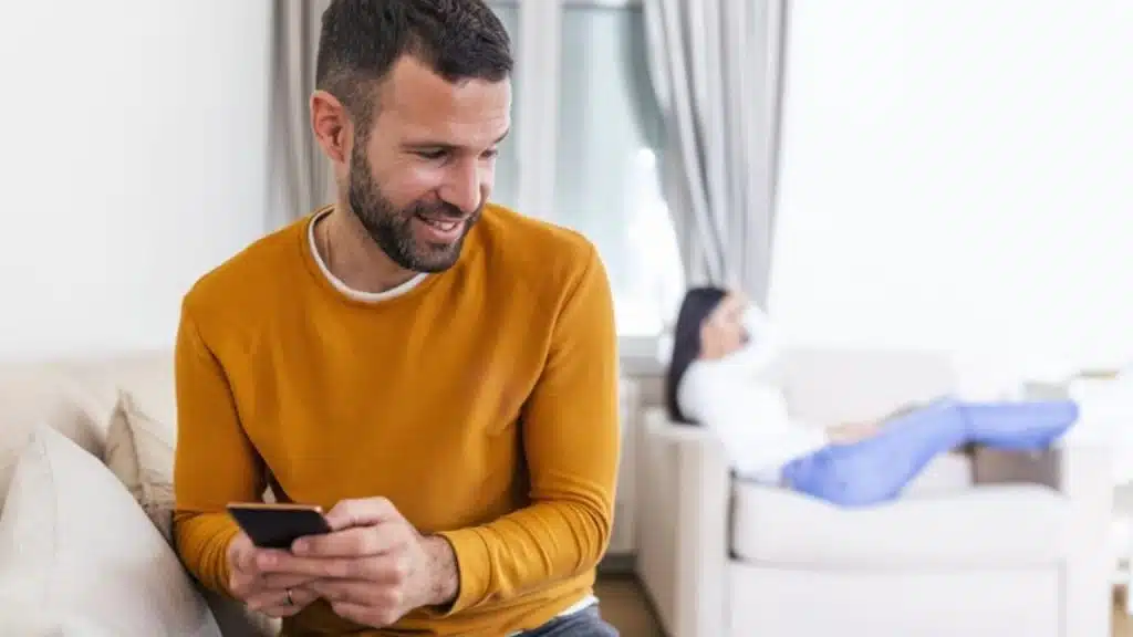 A man busy browsing on his phone instead of having an intimate conversation with his wife