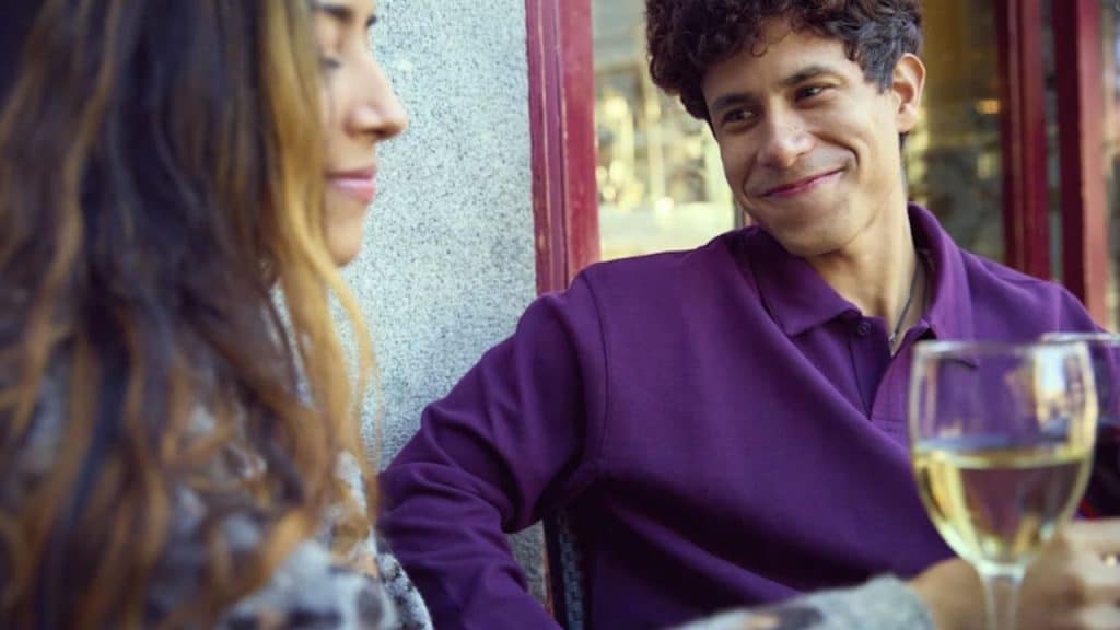 Couple at a café, woman looking uncomfortable as the man talks