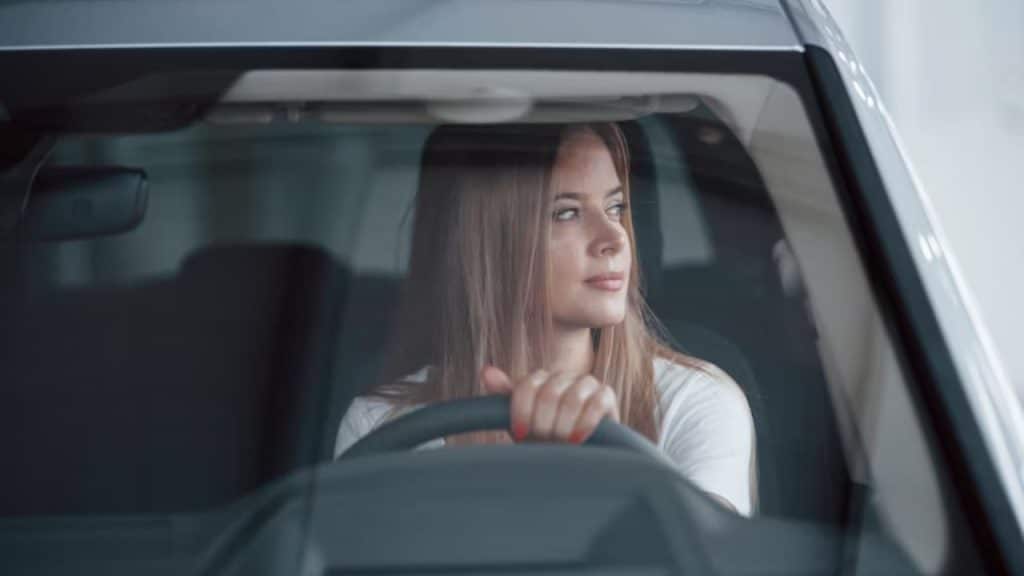 Woman sitting in her car alone, appearing contemplative