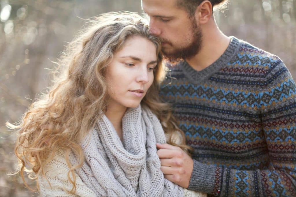 A man kissing a woman’s head 