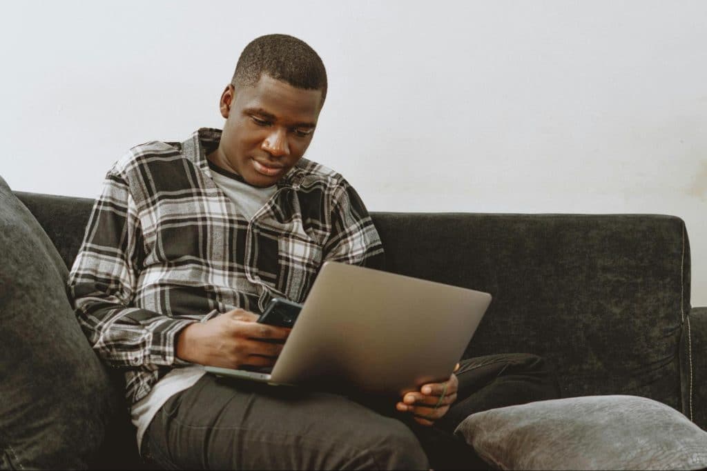 A man smiling while looking at the laptop 