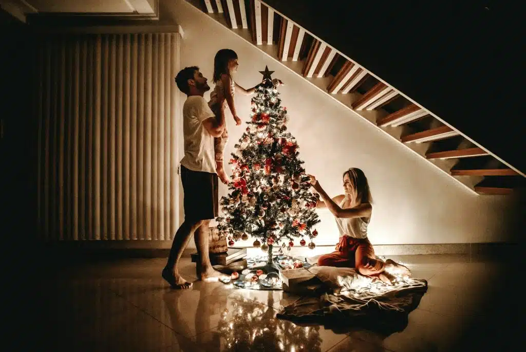 The family is decorating their christmas tree.
