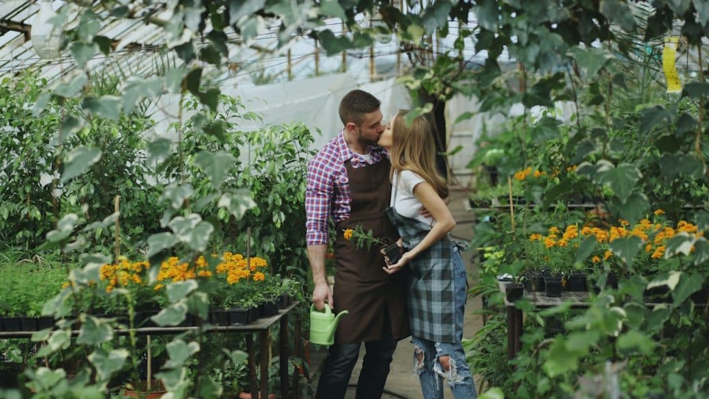 A couple kissing in a botanical garden.