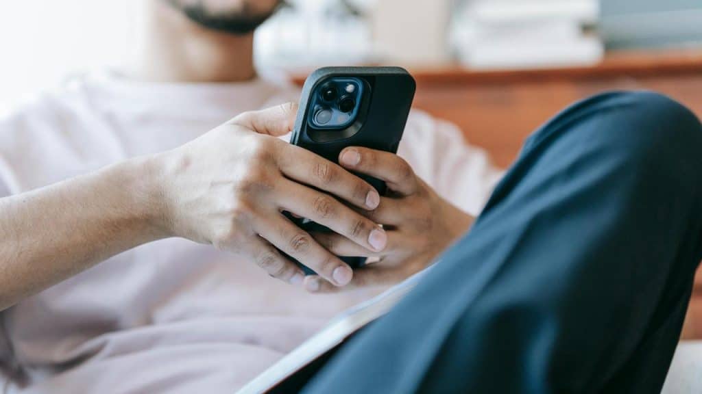 A person sitting and holding a smartphone.