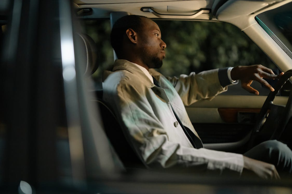 Man Wearing a Coat Sitting Inside a Car
