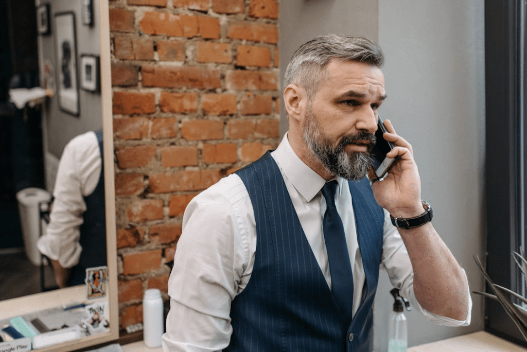 A Bearded Man Talking with Someone Using His Smartphone
