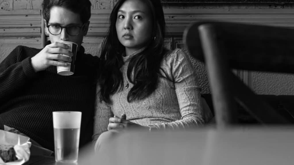 Couple at dinner, woman looking smug as man appears frustrated