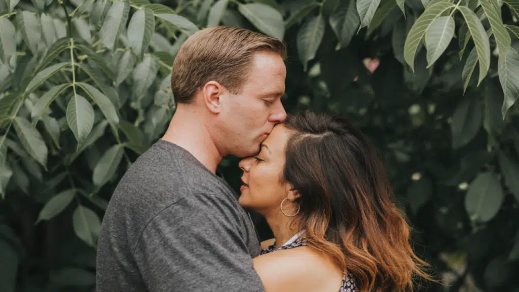 A man kissing his wife on the forehead