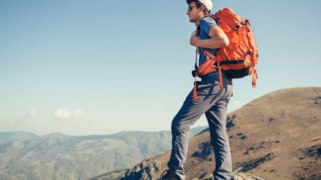 Man hiking on a mountain trail looking inspired