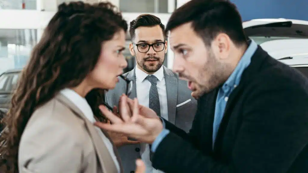 A heated public argument between a man and woman as a man in a suit mediates.