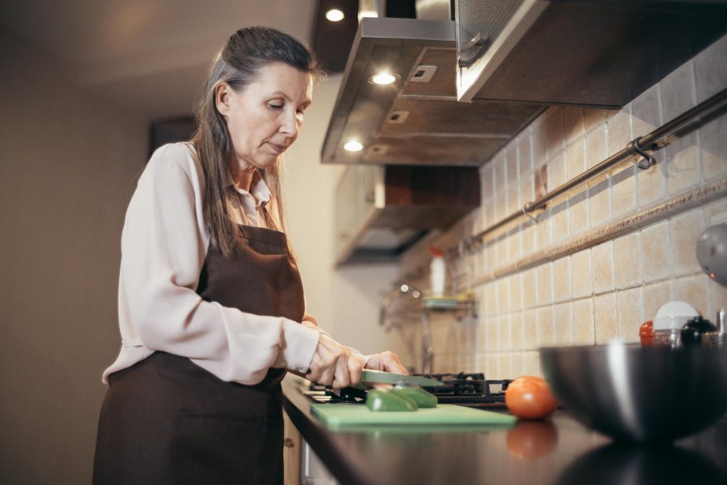 The woman is cooking in her kitchen.