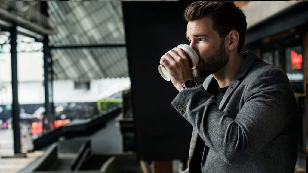 Side view of man drinking hot coffee.