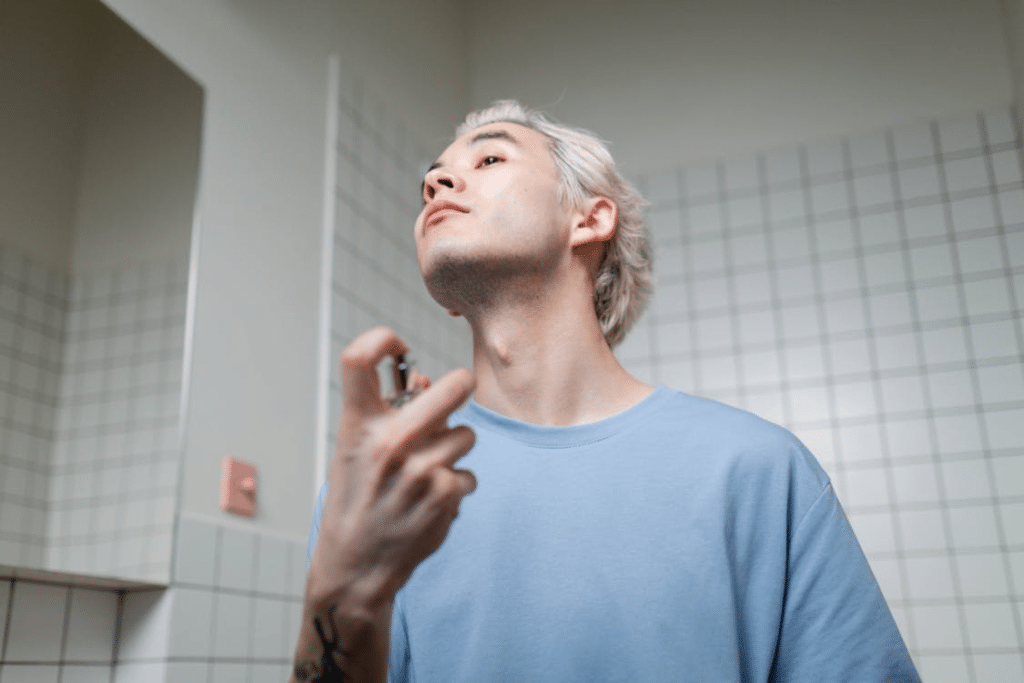 Man in Blue Crew Neck T-shirt Applying Perfume