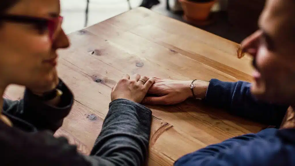 A couple holding hands in a cafe