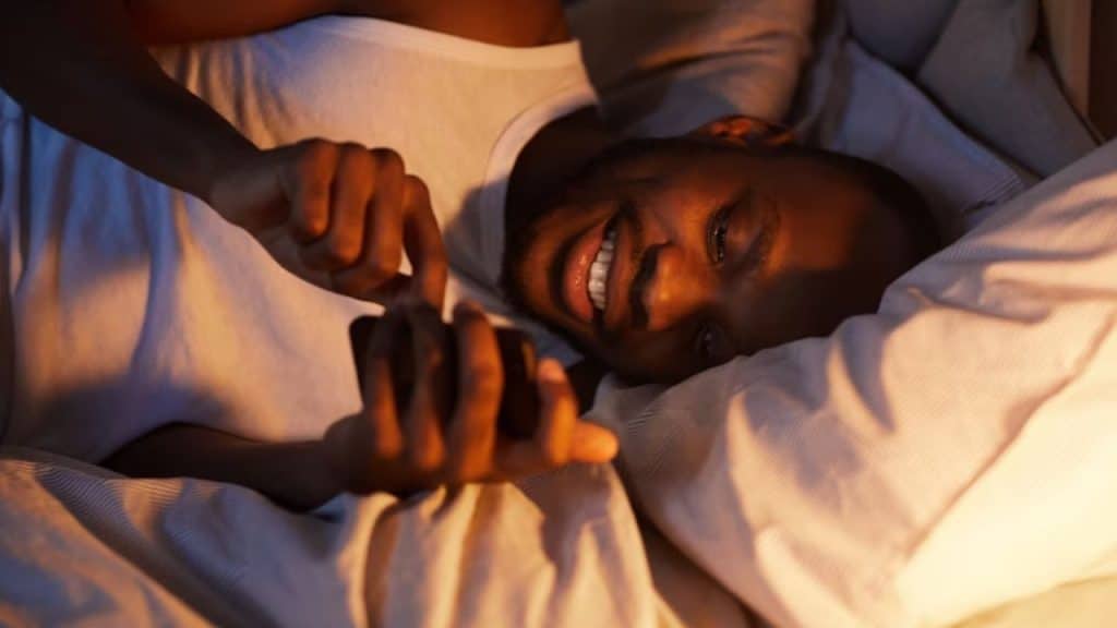 A man scrolling on a dating app at night