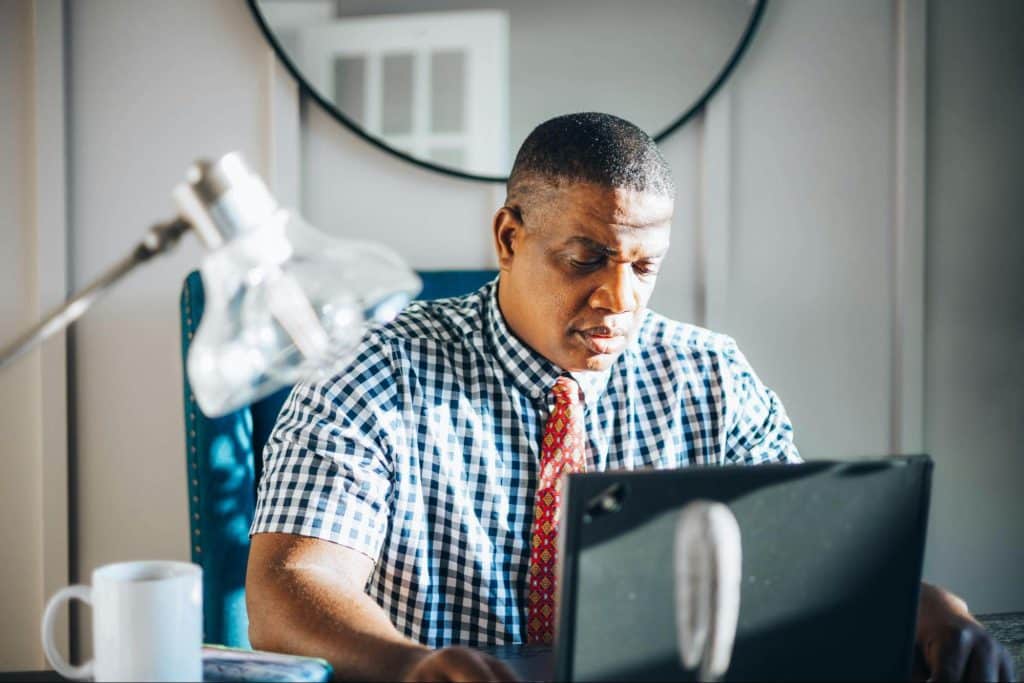 A man in 40s looking at the laptop