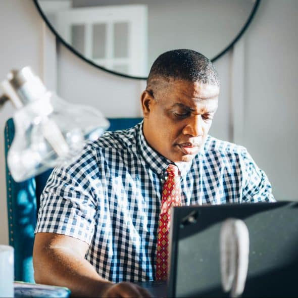 A man in 40s looking at the laptop