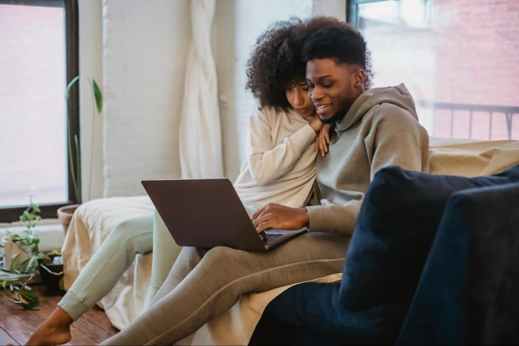 A man and woman looking at the laptop