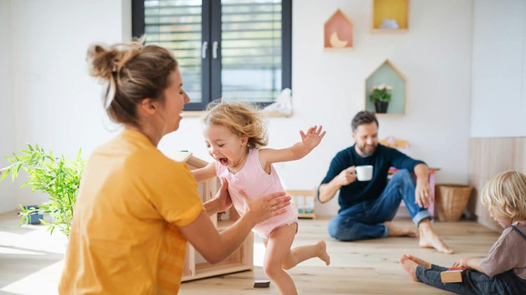 A couple with two kids playing indoors.