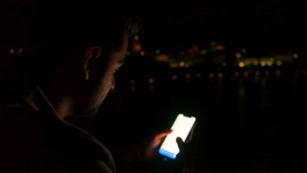 Close-up of a man on his smartphone at night.