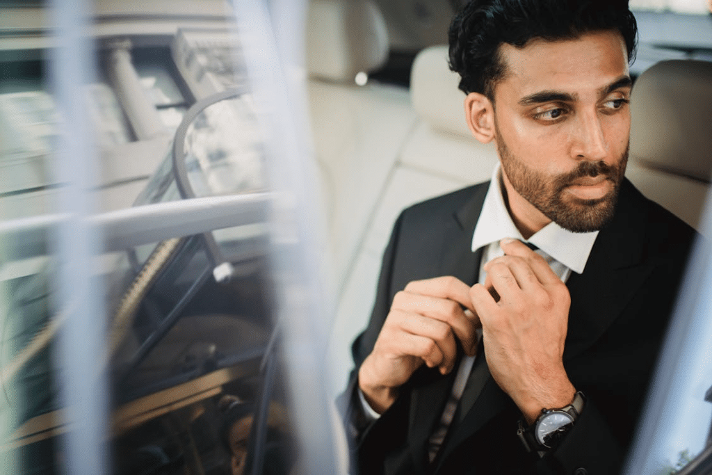 Man in Black Suit Jacket Holding His Necktie