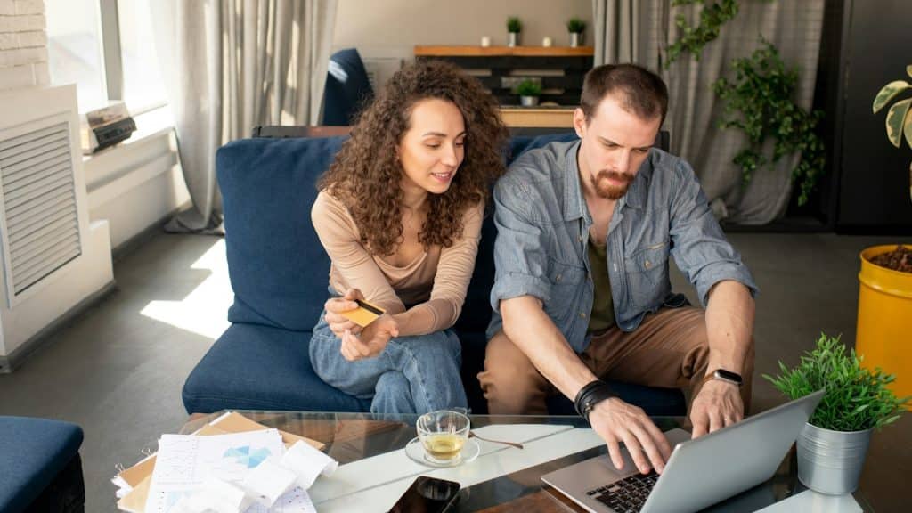 A couple managing accounts while sitting together at a table.