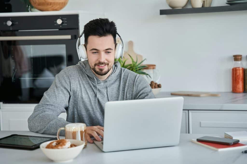 The man is wearing headphones while on a video call.