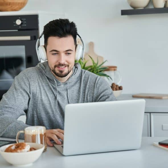 The man is wearing headphones while on a video call.