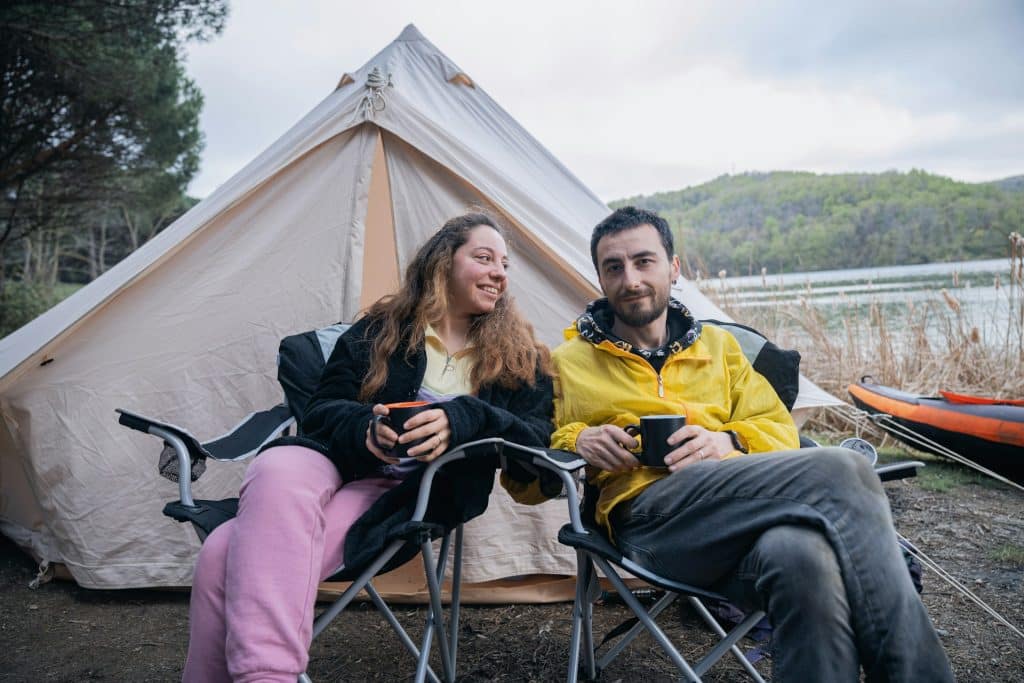 The couple is sitting in front of the tent